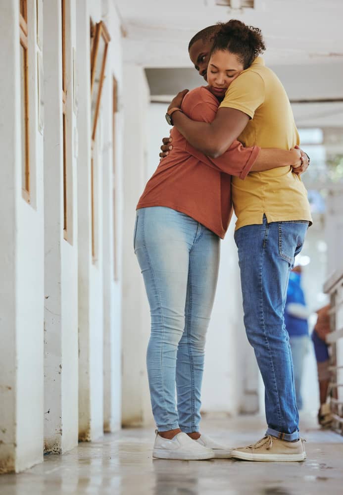 Couple standing by each other, hugging